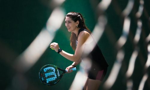 a woman holding a tennis racquet on a tennis court